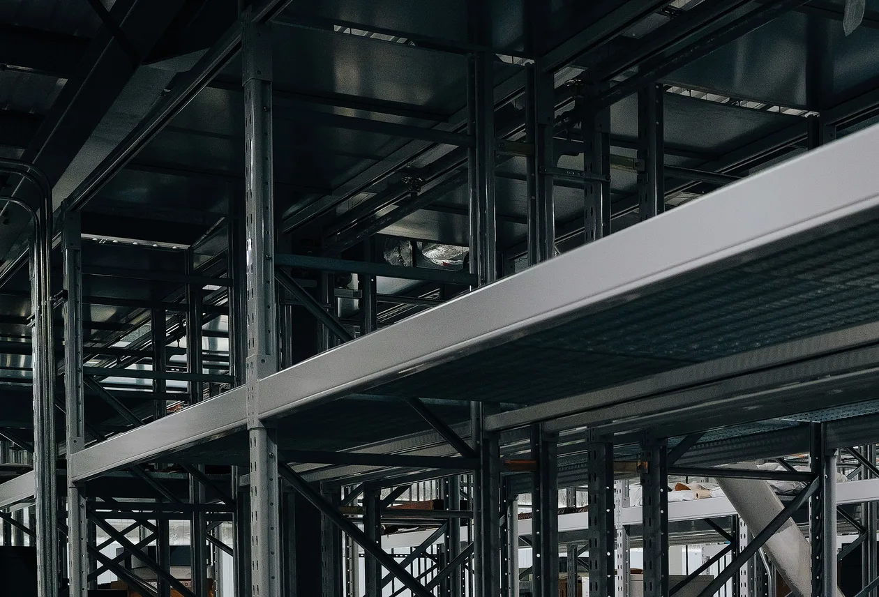Structură metalică industrială de rafturi și depozitare automată pe mai multe niveluri, într-o hală de producție