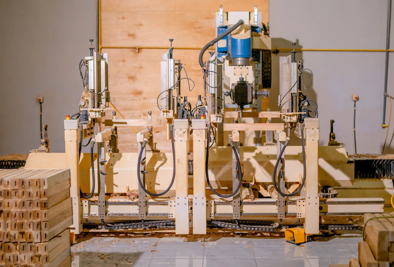 Centru CNC industrial cu patru capete de găurire vertical, procesând bare de lemn într-un atelier de producție